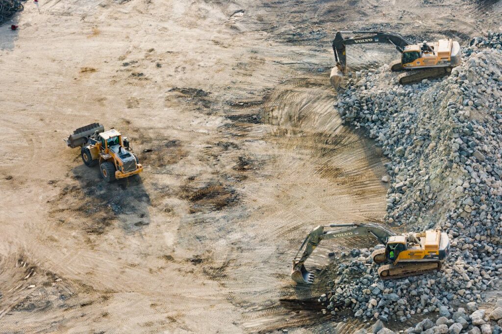 Three Yellow Excavators Near Front End Loader